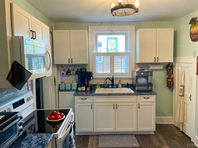 a kitchen with stainless steel appliances granite countertop a sink stove and cabinets