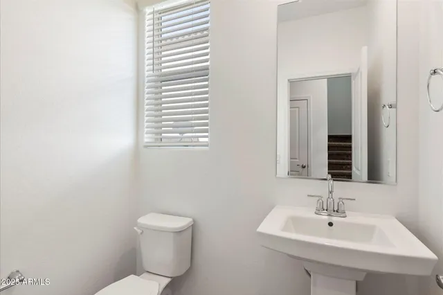 a bathroom with a toilet a sink and mirror