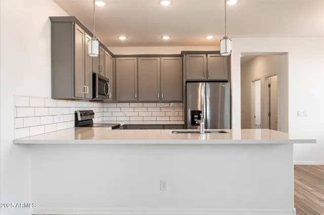 a view of a kitchen with a sink and refrigerator