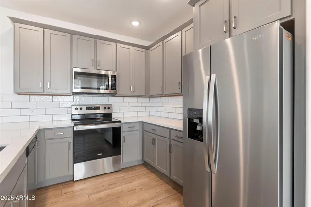 a kitchen with stainless steel appliances granite countertop a refrigerator stove and microwave