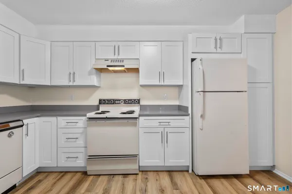 a kitchen with white cabinets and white appliances