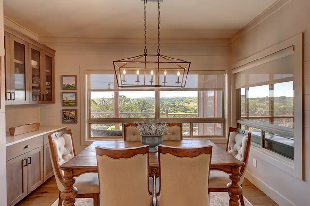 a dining room with furniture a chandelier and wooden floor
