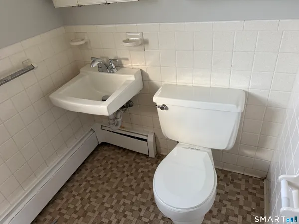 a bathroom with a toilet sink and mirror
