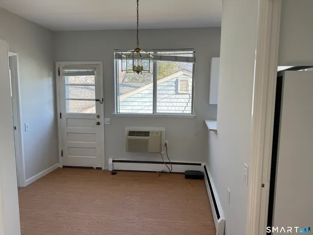 an empty room with windows and chandelier