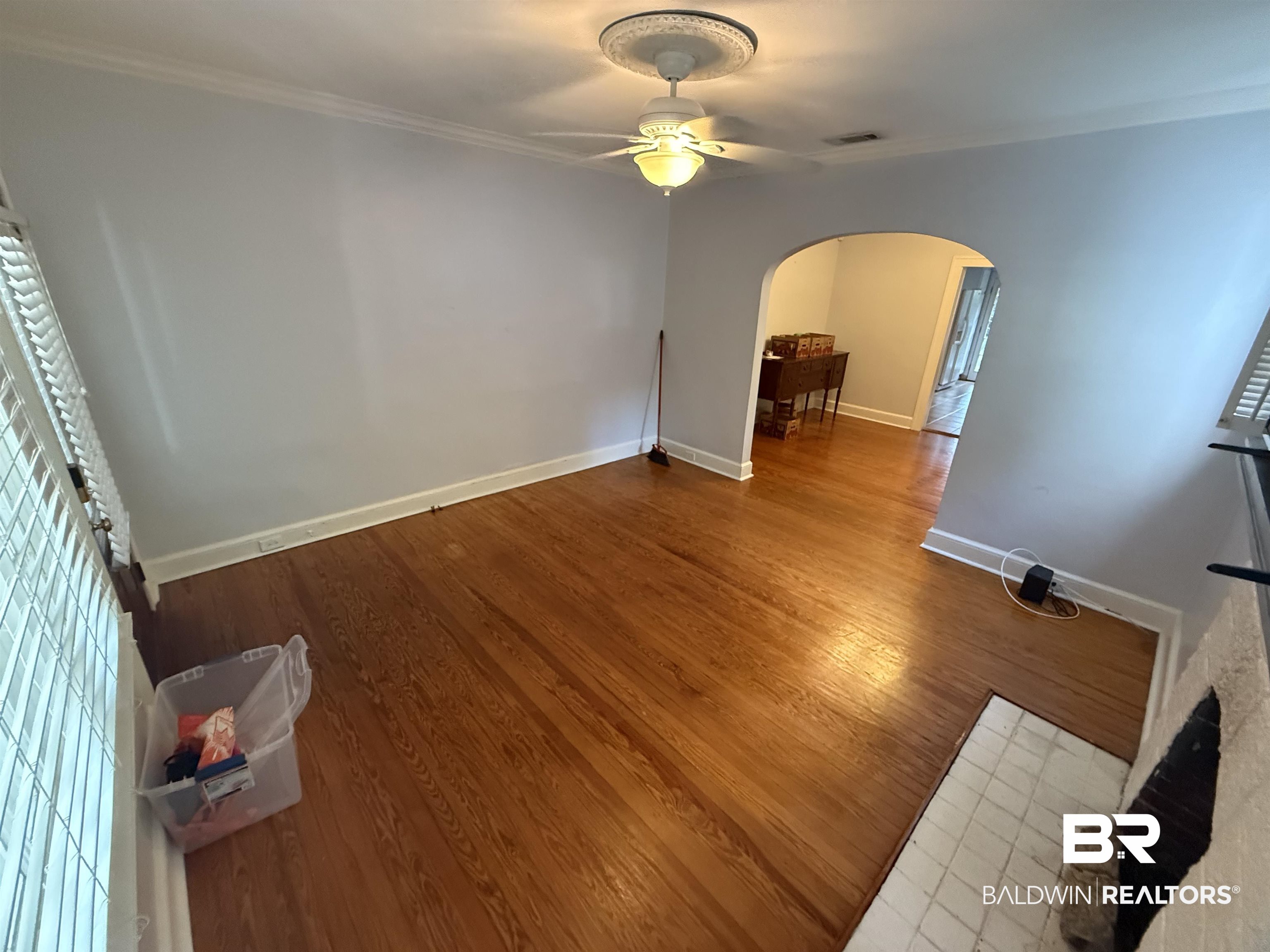 266 Westwood Street Mobile, AL 36606 - Photo 31 of 34 Unfurnished living room with arched walkways, ceiling fan, ornamental molding, and wood finished floors