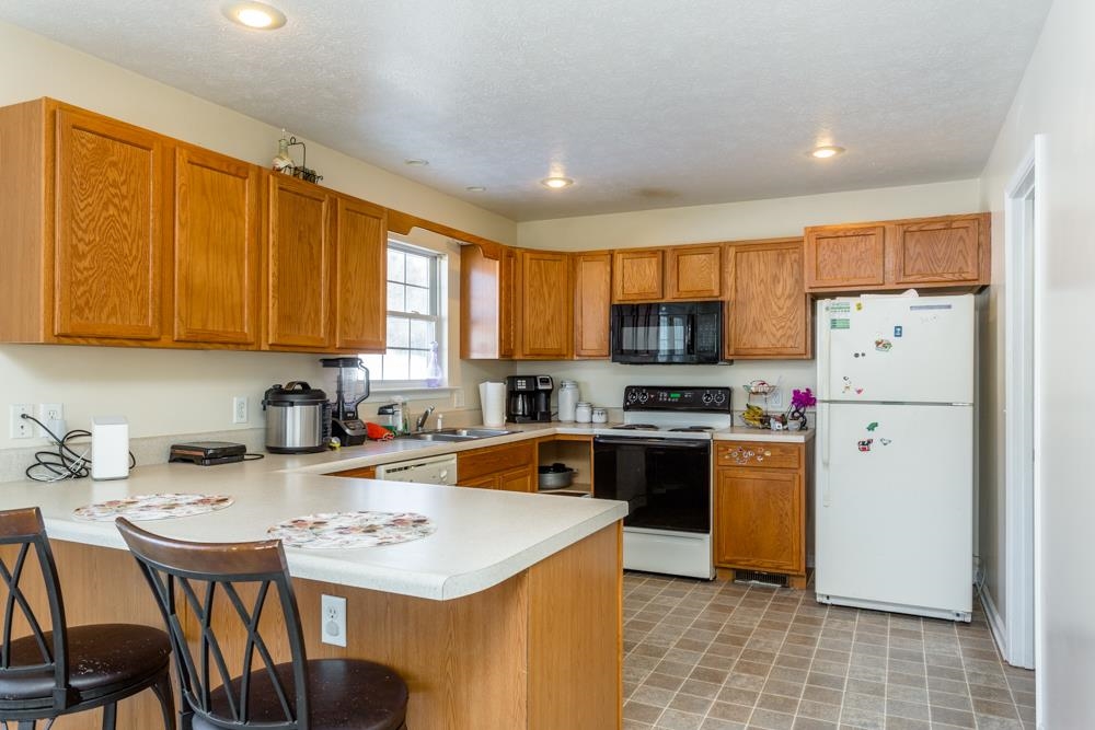555 Pointe Drive Harrisonburg, VA 22801 - Photo 2 of 24 a kitchen with a sink a stove a refrigerator a kitchen island and chairs