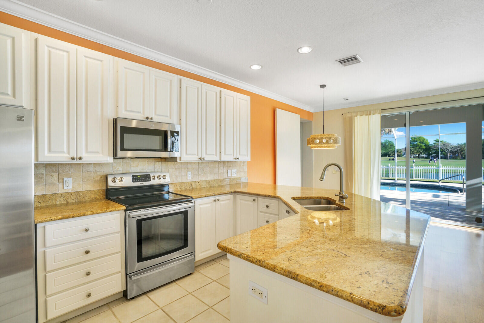142 Barbados Drive Jupiter, FL 33458 - Photo 16 of 53 a kitchen with stainless steel appliances granite countertop a sink a stove and cabinets with wooden floor