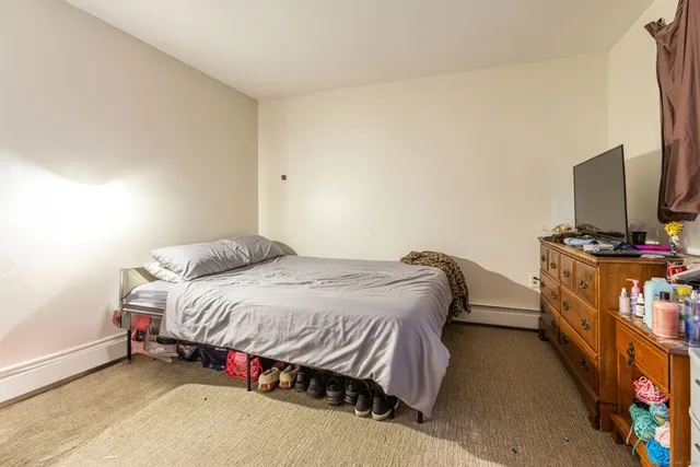 a bathroom with a toilet and a wooden floor