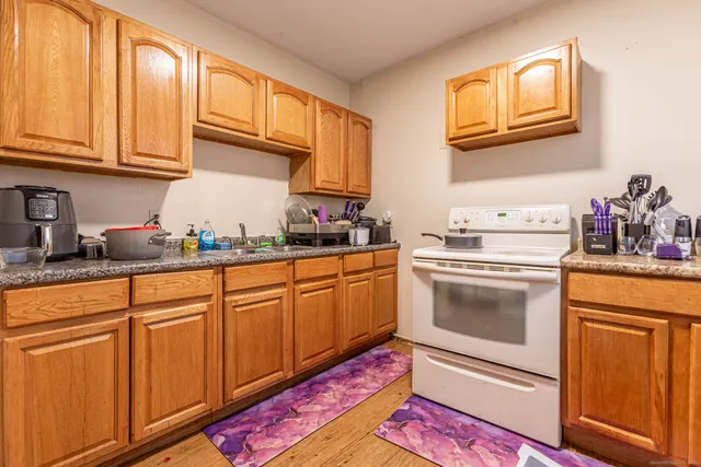 a view of a kitchen with fridge and wooden floor