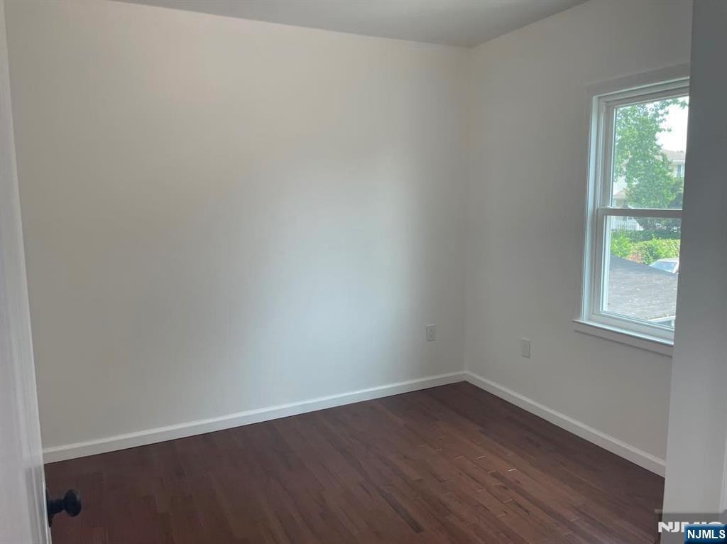 18 Pine Street, Unit 2 Lodi, NJ 07644 - Photo 11 of 16 an empty room with wooden floor and windows