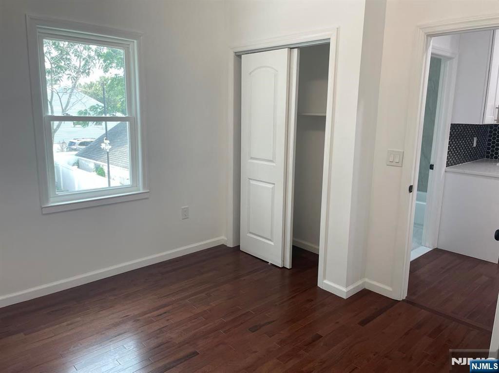 18 Pine Street, Unit 2 Lodi, NJ 07644 - Photo 12 of 16 an empty room with wooden floor and windows