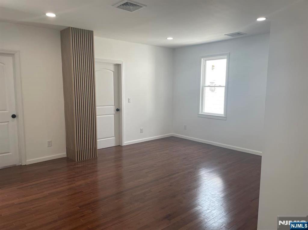 18 Pine Street, Unit 2 Lodi, NJ 07644 - Photo 2 of 16 an empty room with wooden floor and windows