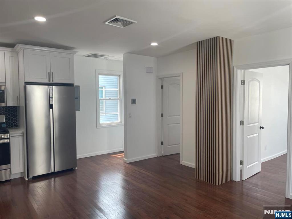 18 Pine Street, Unit 2 Lodi, NJ 07644 - Photo 4 of 16 a view of an empty room with wooden floor and a refrigerator