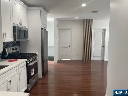 a kitchen with stainless steel appliances granite countertop a stove and a refrigerator