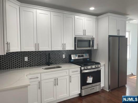 18 Pine Street, Unit 2 Lodi, NJ 07644 - Photo 7 of 16 a kitchen with granite countertop white cabinets and stainless steel appliances