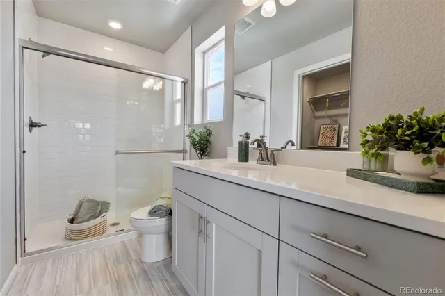 a bathroom with a granite countertop sink a toilet and a mirror