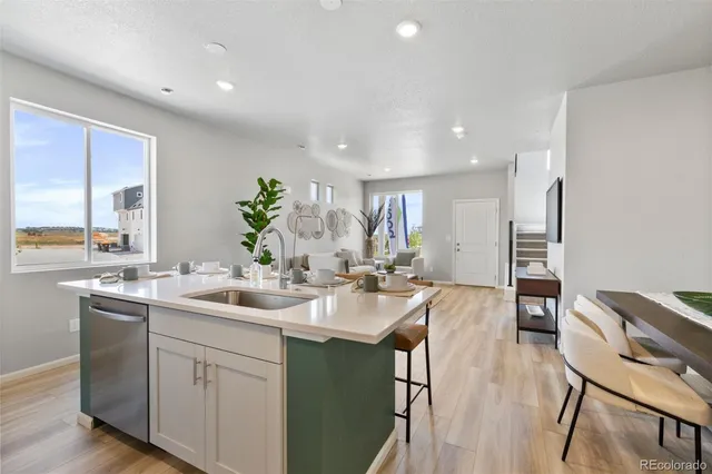 a kitchen with sink refrigerator dining table and chairs