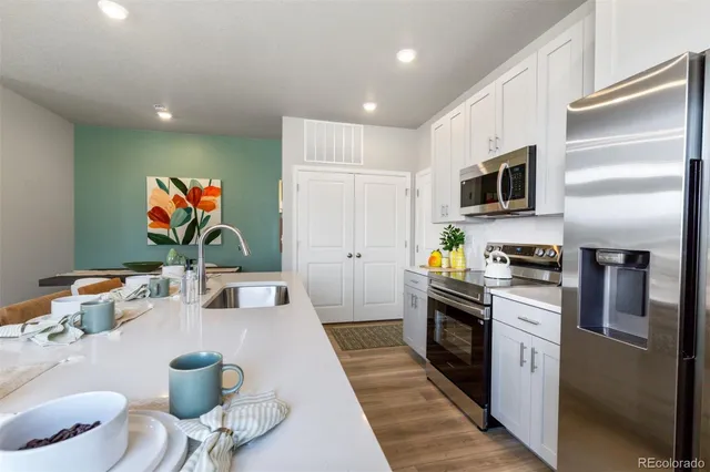 a kitchen with stainless steel appliances kitchen island granite countertop a refrigerator and a stove top oven