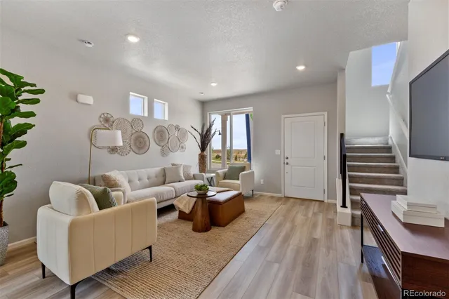 a living room with furniture and wooden floor