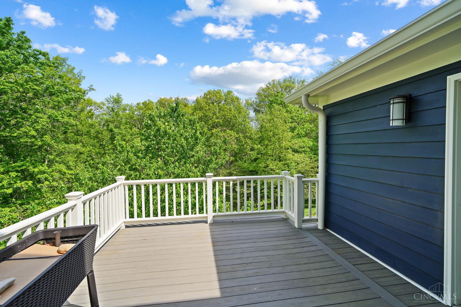 2780 Walsh Road Cincinnati, OH 45208 - Photo 51 of 68 The rear deck seamlessly extends from the screened porch, creating an ideal indoor-outdoor flow for relaxing and entertaining. Constructed with low-maintenance composite decking, it offers both durability and lasting appeal. Generously sized and thoughtfully positioned, the deck provides a pleasant vantage point overlooking the backyard—perfect for morning coffee, outdoor dining, or enjoying the surrounding greenery in comfort.