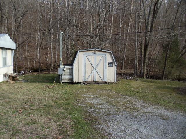 785 Cates Road Lawrenceburg, TN 38464 - Photo 14 of 17 a backyard of a house with a barn and large trees