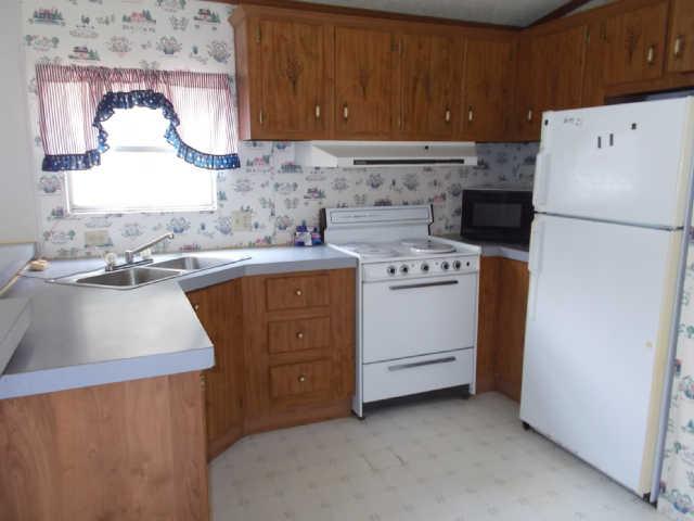 785 Cates Road Lawrenceburg, TN 38464 - Photo 5 of 17 a kitchen with a sink a stove and refrigerator