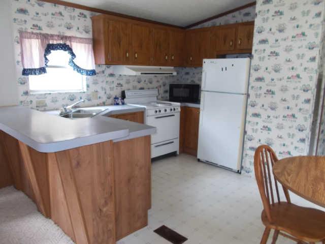 785 Cates Road Lawrenceburg, TN 38464 - Photo 6 of 17 a kitchen with a sink a stove a refrigerator and a refrigerator