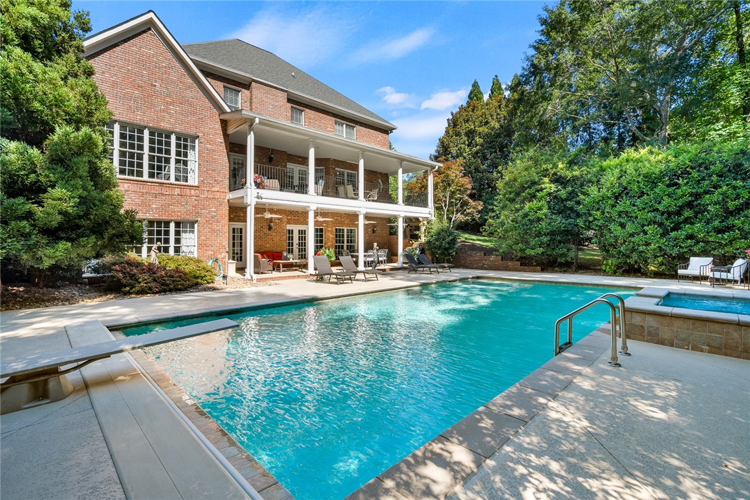 200 Graylyn Drive Anderson, SC 29621 - Photo 41 of 48 An inviting backyard oasis offers a sparkling pool and spa, set against a two-story brick residence with covered patios.