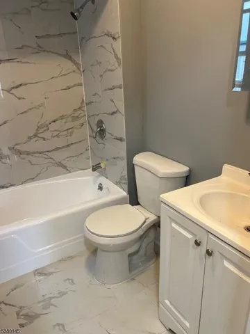 a white toilet sitting next to a bath tub and a shower