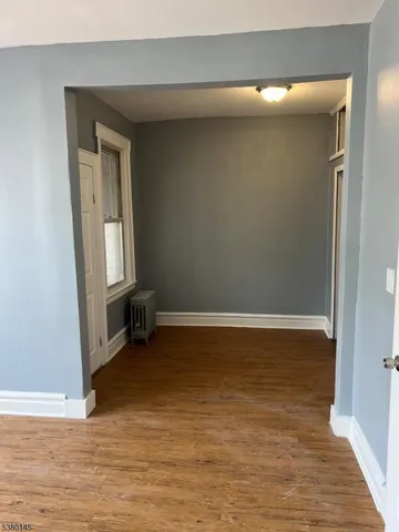 an empty room with wooden floor and mirror