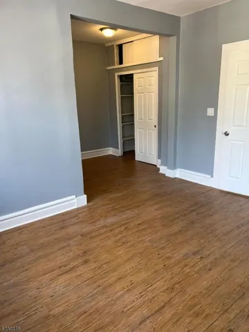 an empty room with wooden floor and closet