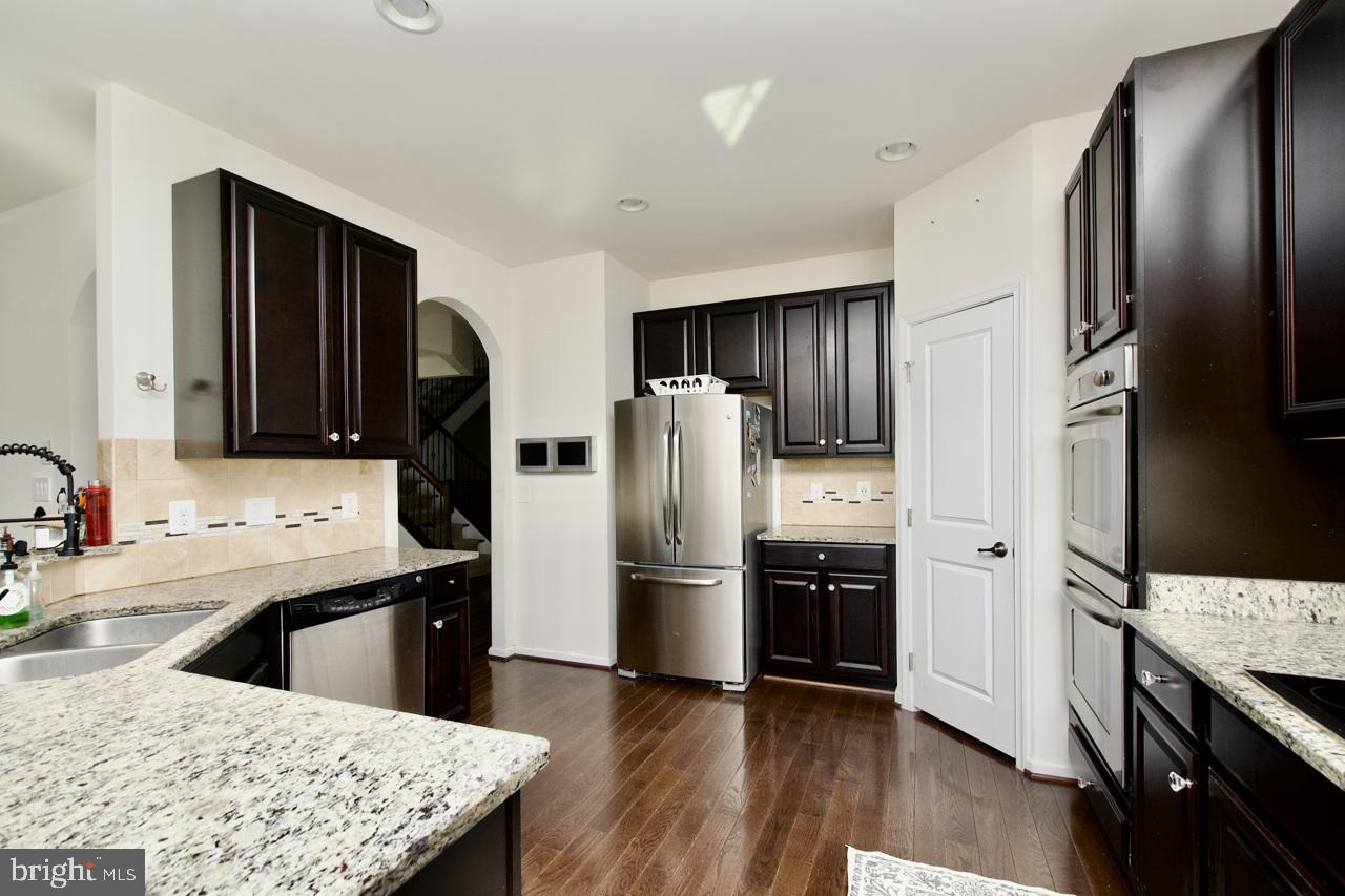 21 Runyon Drive Stafford, VA 22554 - Photo 13 of 43 a kitchen with stainless steel appliances kitchen island granite countertop a refrigerator a stove and a sink