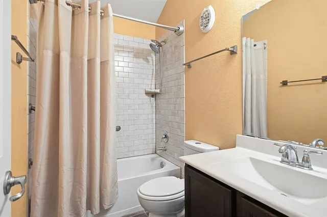 a bathroom with a granite countertop sink toilet a mirror a vanity and shower