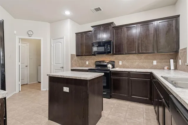 a kitchen with kitchen island granite countertop stainless steel appliances and sink