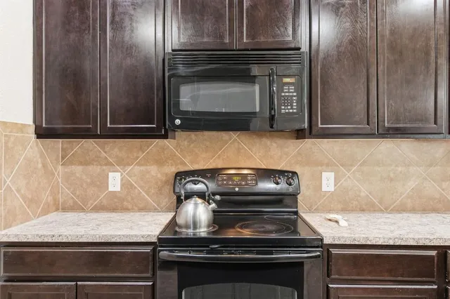 a stove top oven sitting inside of a kitchen