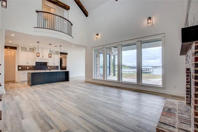 a view of an empty room with kitchen view and a window
