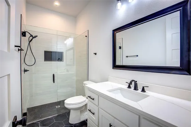 a bathroom with a toilet sink a mirror and shower