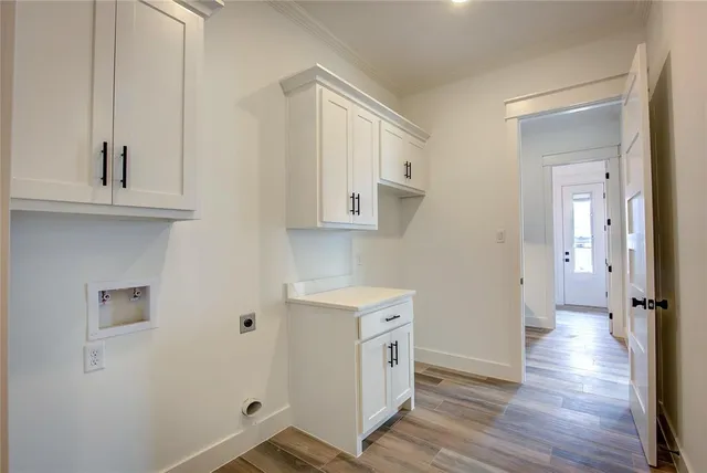 a view of a kitchen with white cabinets and wooden floor