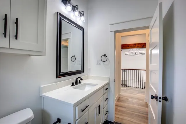 a bathroom with a sink a toilet and mirror