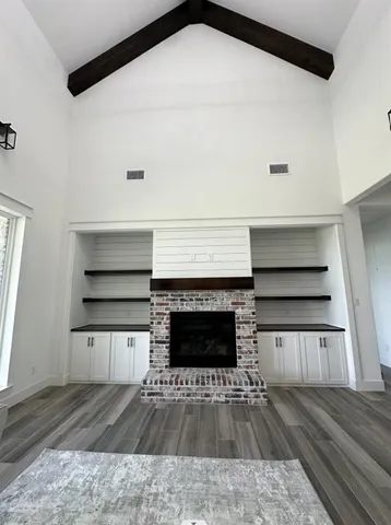 a living room with a fireplace and wooden floor
