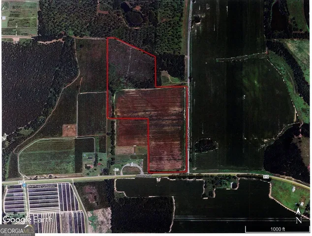 a view of a dry yard with wooden fence