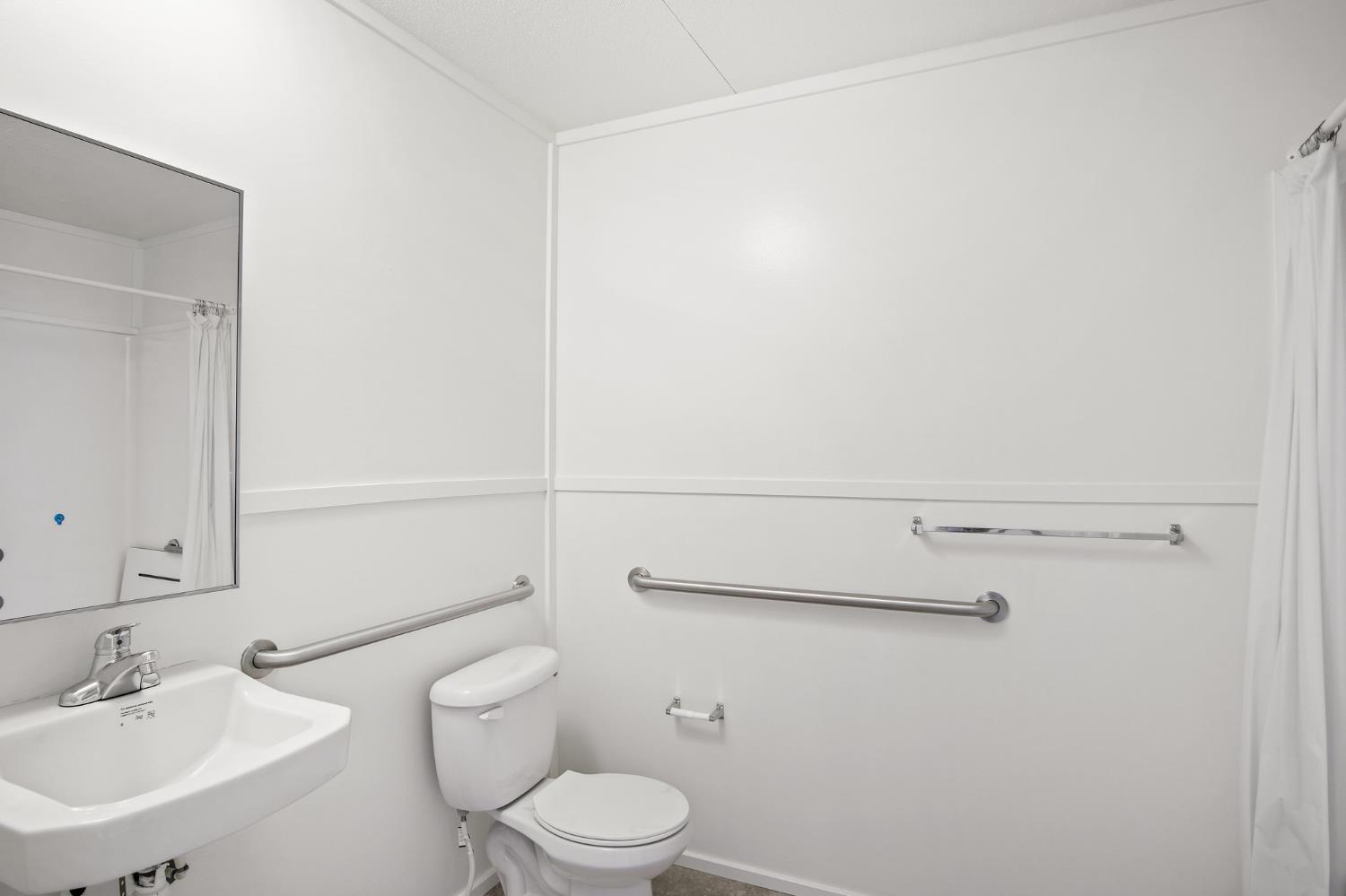 1400 Meredith Avenue, Unit 81 Gustine, CA 95322 - Photo 15 of 29 a bathroom with a toilet a sink and mirror