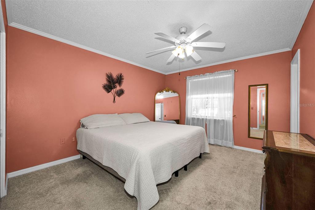 9427 Cape Charles Avenue New Port Richey, FL 34655 - Photo 21 of 82 a bedroom with a bed and a chandelier