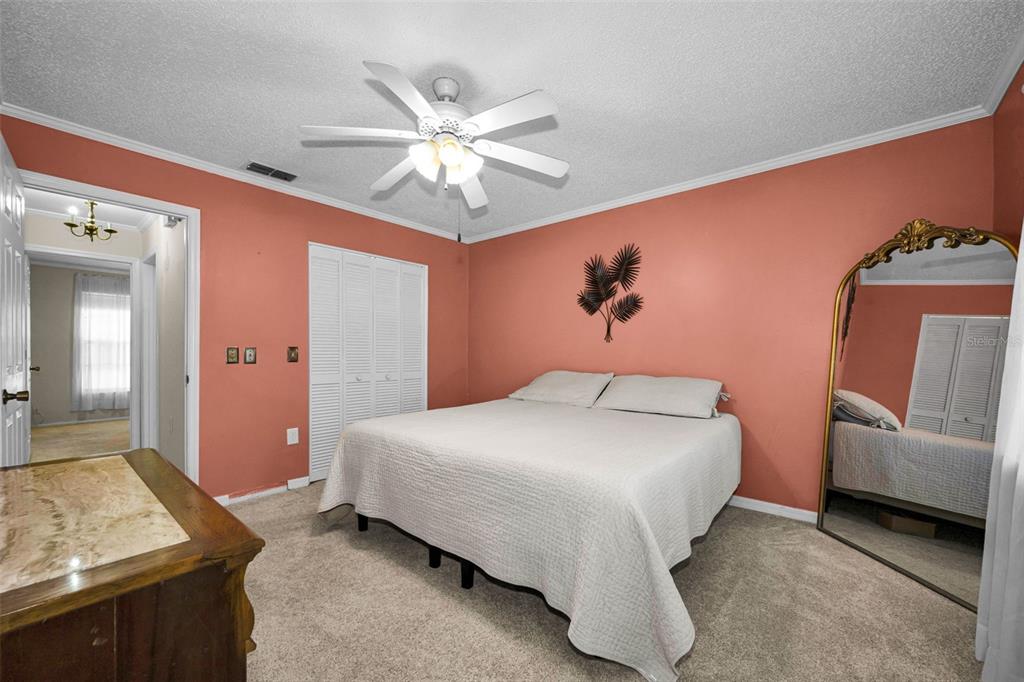 9427 Cape Charles Avenue New Port Richey, FL 34655 - Photo 23 of 82 a bedroom with a bed and a chandelier
