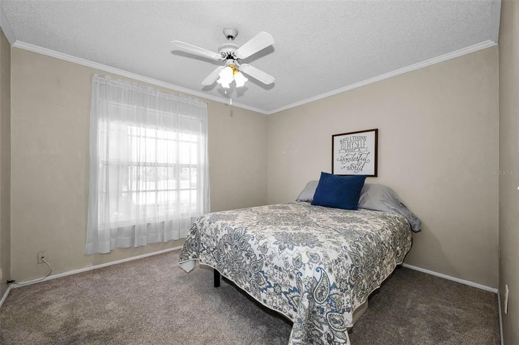 9427 Cape Charles Avenue New Port Richey, FL 34655 - Photo 25 of 82 a bedroom with a bed and a chandelier