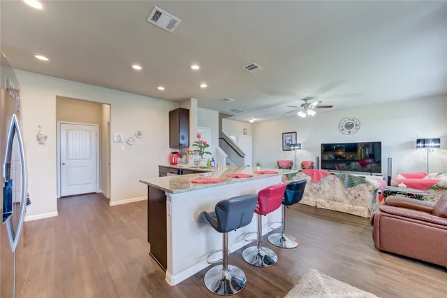 a living room with kitchen island furniture and a flat screen tv