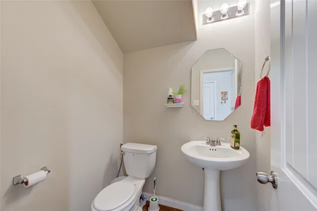 a bathroom with a sink toilet and a mirror