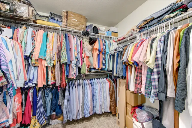 a view of walk in closet with clothes and shoes
