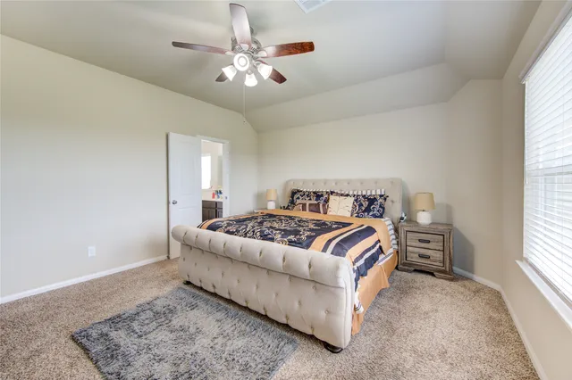 a bedroom with a large bed and a chandelier