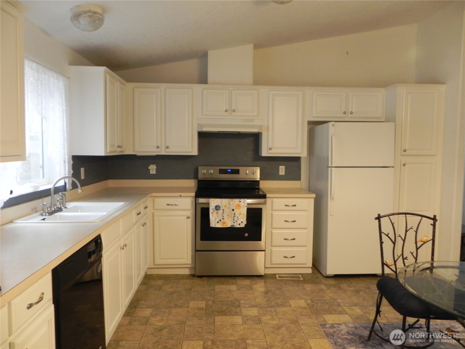 230 Silver Street Republic, WA 99166 - Photo 8 of 25 a kitchen with granite countertop a stove top oven a sink and white cabinets